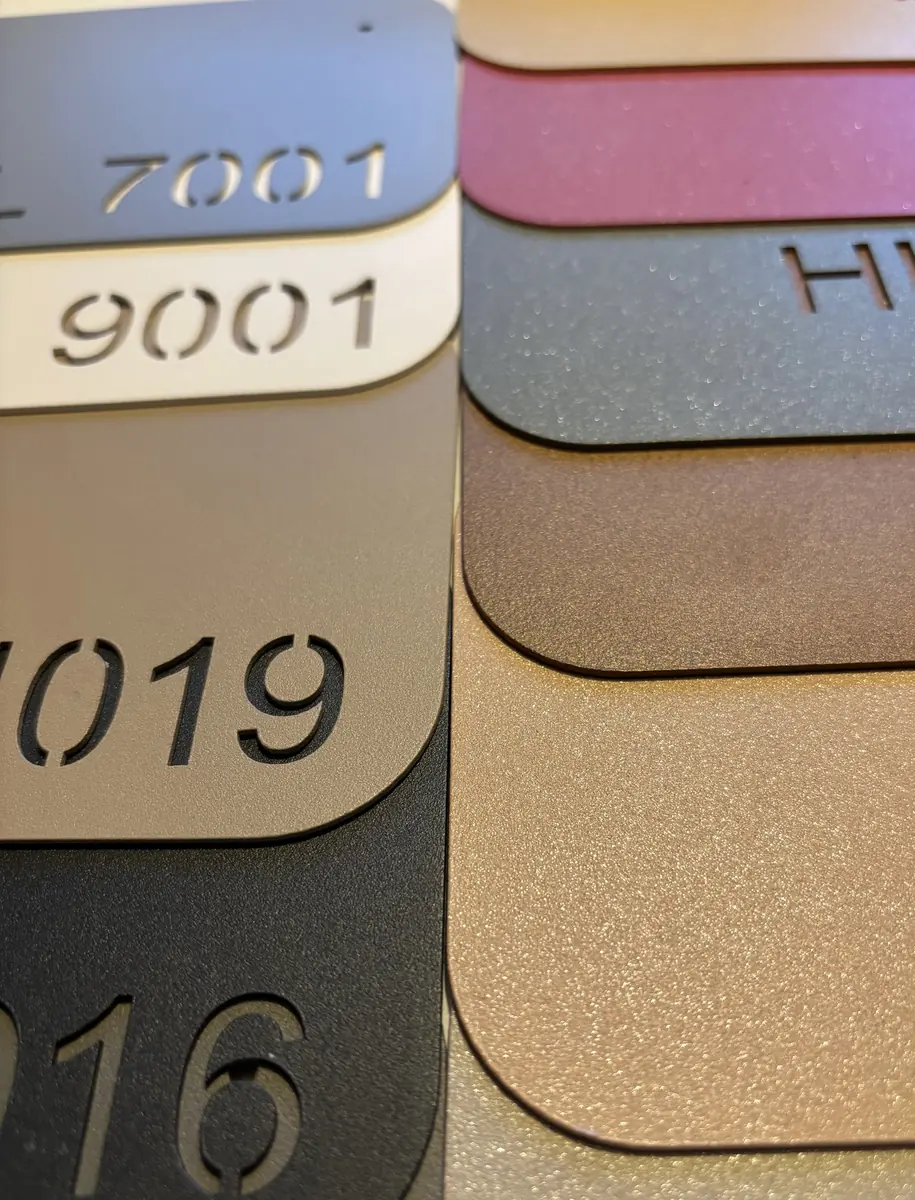 Close-up van poedercoating stalen in standaard RAL-kleuren 7001, 9001, 1019 en 7016